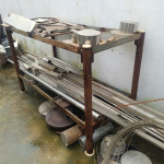 Prateleira em aço carbono com diversos retalhos de inox: tubos, barras e pequena quantidade de limalha de alumínio